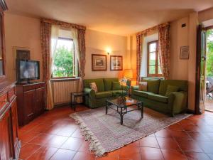 a living room with green couches and a tv at Cozy Holiday Home with Pool in Sienna Italy in Siena +71 photos