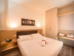 sypialnia z białym łóżkiem z łukiem w obiekcie Elegant apartment in resort with swimming pool featuring nature and tranquillity w mieście Foligno