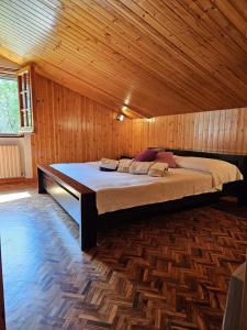 Un dormitorio con una cama grande en una habitación de madera. en Villa Onde e Ulivi, en San Bernardo
