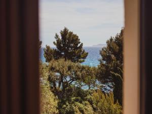 a view of the ocean from a window at 2-room holiday flat with sea view in Residence du Bailli, Rayol-Canadel-sur-Mer in Rayol-Canadel-sur-Mer