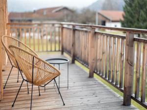 un par de sillas sentadas en una terraza de madera en Inzell Chalets with private pool, en Inzell