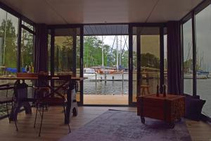 a room with a table and a boat in the water at Houseboat Leni, Flensburg in Flensburg