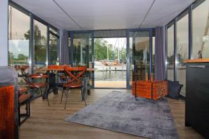 a dining room with a table and chairs and windows at Houseboat Leni, Flensburg in Flensburg