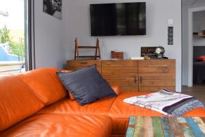 an orange couch with a pillow on it in a living room at Houseboat Leni, Flensburg in Flensburg +36 photos