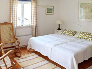 a bedroom with a bed and a chair and a window at 4 star holiday home in Slöinge in Slöinge