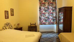 a bedroom with a bed and a window with a curtain at Albergo Bernini in Siena