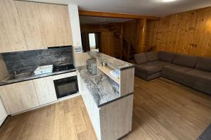 a kitchen and a living room with a couch at Vila Casa Familiei Poiana Braşov in Poiana Brasov