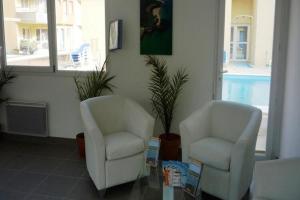 two chairs and a table in a living room at Residence Les Isles de Sola, Grandcamp, Studio in Grandcamp-Maisy