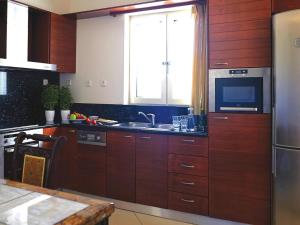 a kitchen with wooden cabinets and a stainless steel refrigerator at Villa in Platanias with a private pool in Plataniás +24 photos