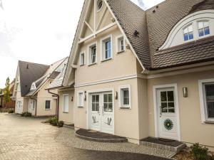 a row of houses with white doors on a driveway at Apartment, Zingst in Zingst