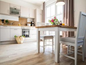 a kitchen with white cabinets and a table and chairs at Apartment, Zingst in Zingst