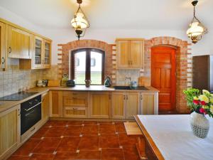 cocina con armarios de madera, mesa y ventana en Comfortable holiday home, Grabczyn, en Grąbczyn