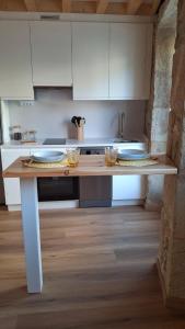 a kitchen with a table with plates on it at A de Laura in Lariño +5 photos