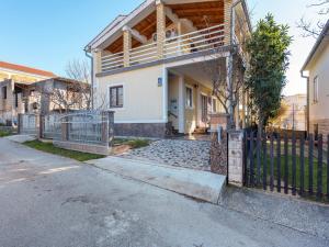 a house with a fence in front of it at Beautiful Apartment in Jasenice near Sea in Jasenice