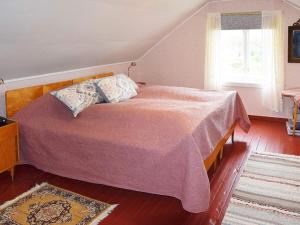 a bedroom with a bed with a pink blanket and a window at 7 person holiday home in Skutvik in Skutvika