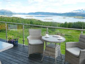 a table and chairs on a deck with a view at 7 person holiday home in Skutvik in Skutvika