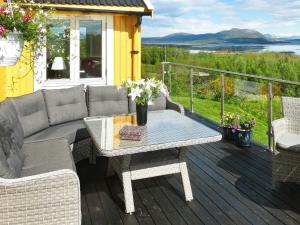 a patio with a couch and a table on a deck at 7 person holiday home in Skutvik in Skutvika