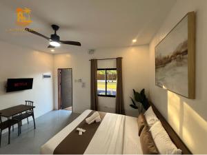 - une chambre avec un lit, une table et un ventilateur de plafond dans l'établissement Casa Marga Resort - Panglao, Bohol, à Panglao