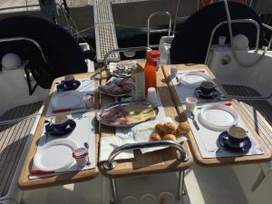 una mesa con platos de comida en la parte superior de un barco en Madyson Sailing en La Spezia