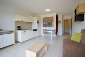 a kitchen and living room with a couch and a table at Residence du Château de Jouarres, Azille - Studio 2 pers with balcony in Azille
