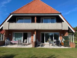 une maison avec des chaises et une table devant elle dans l'établissement Farmstay Neuendorfkrug, Lütow, à Lütow