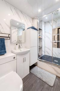 a white bathroom with a shower and a sink at One Bed Room Apartment in Aberdeen City Centre Home Away From Home in Aberdeen