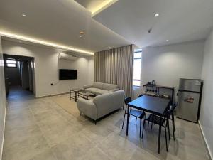 una sala de estar con una mesa y un sofá en اجنحة راف, en Medina 27 fotos más