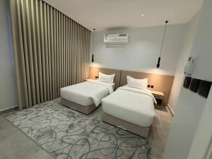 a hotel room with two beds and a window at اجنحة راف بني حارثة in Medina