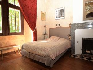 a bedroom with a bed and a fireplace at Castle 12th century with private pool close to Agen in Saint-Caprais-de-Lerm