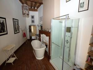 a bathroom with a tub and a glass shower at Castle 12th century with private pool close to Agen in Saint-Caprais-de-Lerm