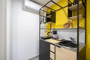 eine Küche mit gelben und schwarzen Schränken und einem Waschbecken in der Unterkunft Dimora dei Colori - Yellow Light in Bari
