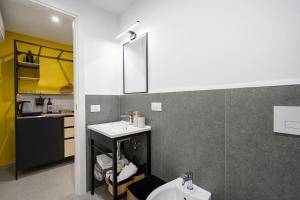ein Badezimmer mit Waschbecken und Spiegel in der Unterkunft Dimora dei Colori - Yellow Light in Bari