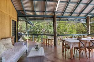 a porch with a couch and a table and chairs at Straddie Hideout - Sleeps 9 - Pet Friendly in Point Lookout
