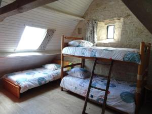 a bedroom with two bunk beds and a window at Country house on a beautiful medieval estate in Saint-Lo-dʼOurville