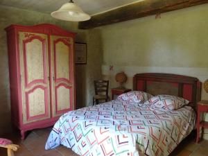 a bedroom with a bed and a red cabinet at Country house on a beautiful medieval estate in Saint-Lo-dʼOurville