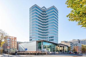 un edificio alto de cristal en una ciudad en Holland House Hotel Cardiff By Sunday, en Cardiff