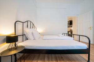 ブダペストにあるGreen Greguss Calm Chic w AC by M2 Metroのベッドルーム1室(白いシーツとランプ付) +6枚の写真