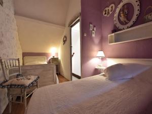 a bedroom with purple walls and a bed and a chair at Charming Gîte in France for a Private Getaway in Mézy-Moulins