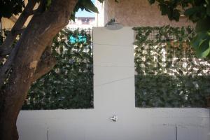 a white fence with green plants on it at Holiday Luxury Room in Giardini Naxos