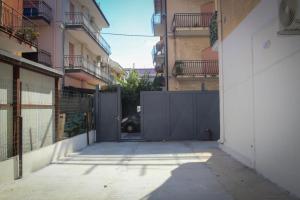 an empty alley with a gate in a building at Holiday Home Suite in Giardini Naxos