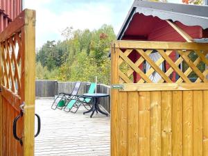 a wooden gate with a table and chairs on a deck at 5 person holiday home in ULRIKA in Rimforsa
