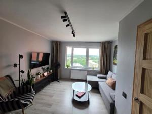 a living room with a couch and a table at Panorama Suite Jelgava in Jelgava