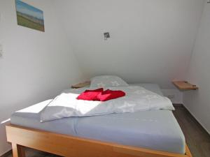 a bed with white sheets and a red blanket at Semi-detached house, Zingst in Zingst