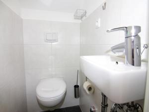a white bathroom with a sink and a toilet at Semi-detached house, Zingst in Zingst