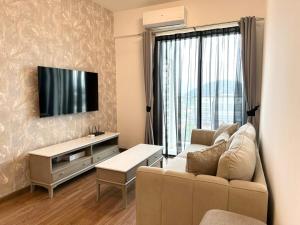 a living room with a couch and a tv at ICC Suites Ipoh 16th floor in Ipoh