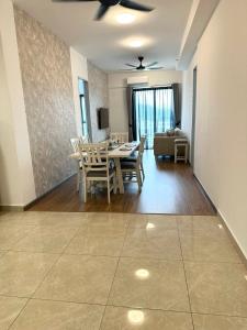 a dining room and living room with a table and chairs at ICC Suites Ipoh 16th floor in Ipoh