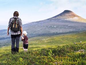a woman and a child standing on a hill with a mountain at 12 person holiday home in IDRE in Idre +1 photo