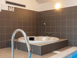 a bathroom with a bath tub and a sink at 22 person holiday home in Jerup in Jerup