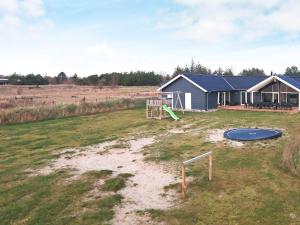a house with a playground in a field at 22 person holiday home in Jerup in Jerup