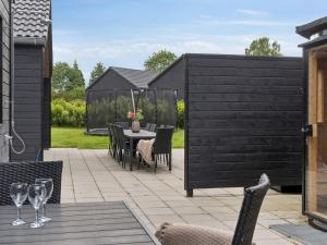a patio with a table and chairs and a fence at 5 star holiday home in Dronningmølle in Dronningmølle